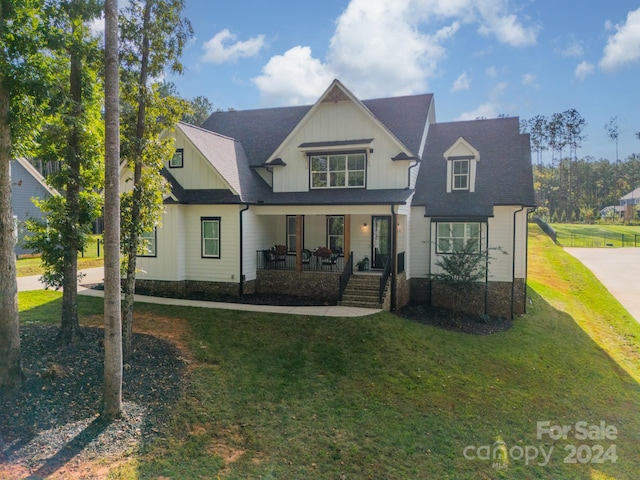 view of front of home with a porch and a front yard