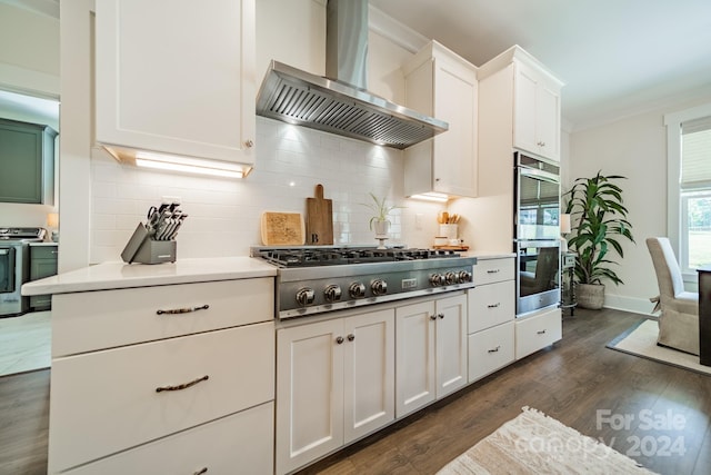 540 Kenway Loop, Mooresville, NC 28117 - kitchen featuring wall chimney range hood, stainless steel appliances, crown molding, white cabinetry, and dark wood-type flooring