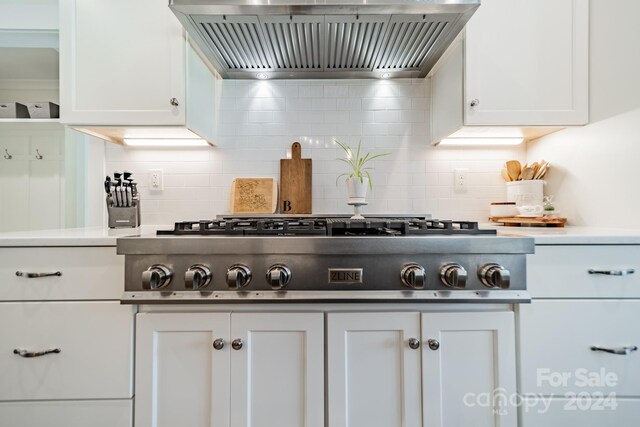 kitchen featuring white cabinets, decorative backsplash, wall chimney range hood, and stainless steel gas cooktop