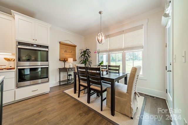 dining area featuring crown molding, dark wood-type flooring, and a chandelier