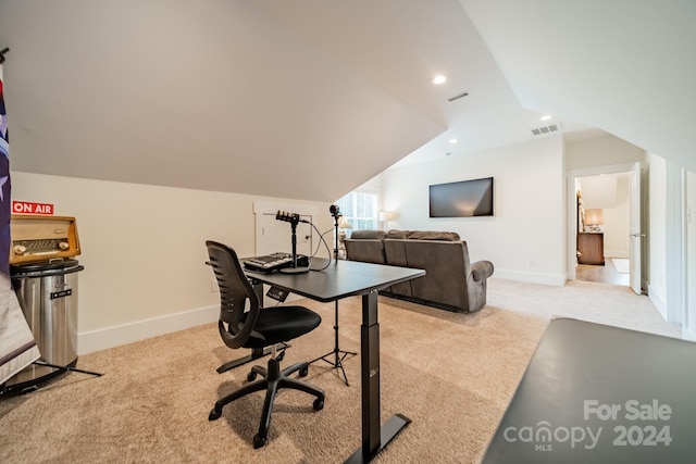 carpeted office space featuring lofted ceiling