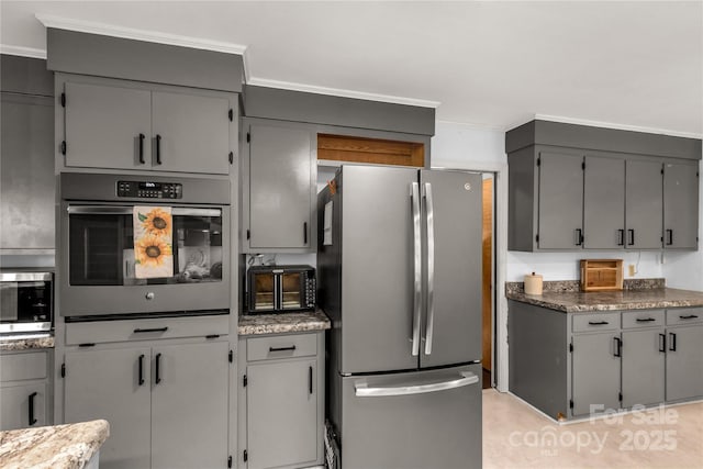 kitchen featuring stainless steel appliances, ornamental molding, gray cabinetry, and stone counters