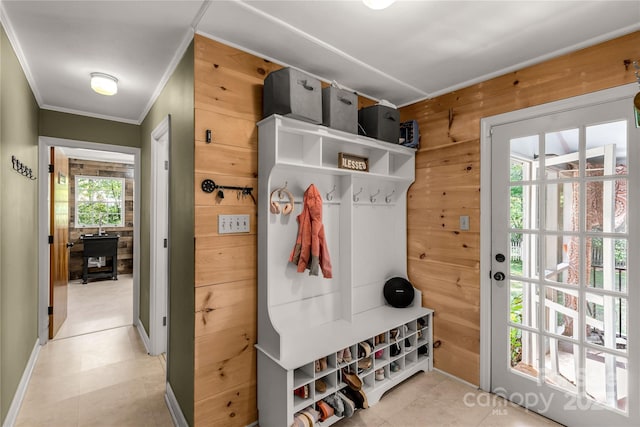 mudroom with crown molding and wood walls