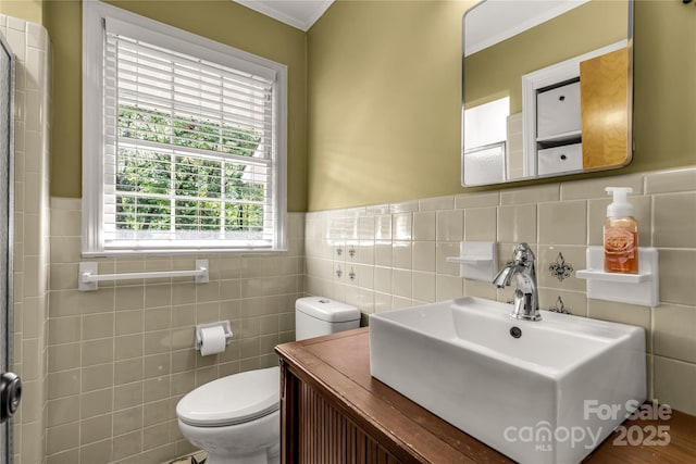 bathroom with crown molding, vanity, toilet, and tile walls