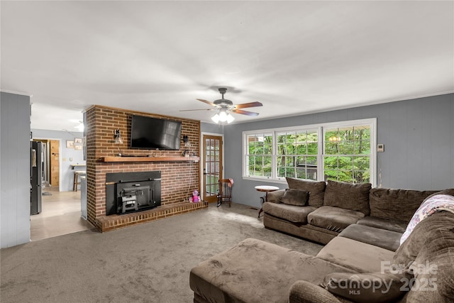 living room featuring a wood stove and ceiling fan