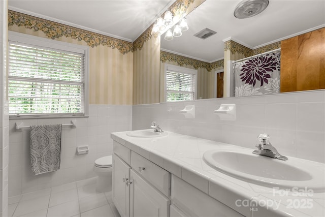 bathroom featuring tile walls, vanity, ornamental molding, tile patterned floors, and toilet