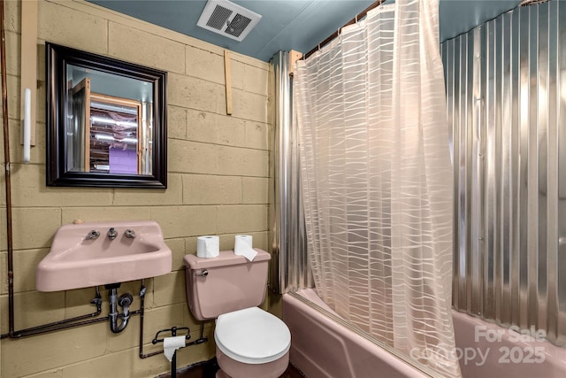 full bathroom featuring sink, shower / bath combination with curtain, and toilet