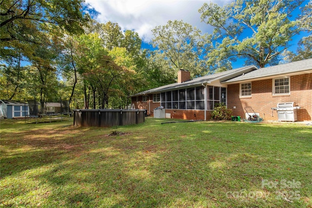 view of yard with a pool and a sunroom