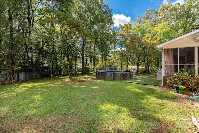 view of yard featuring a fenced in pool and a sunroom