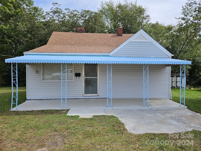 145 33rd St SW, Hickory, NC 28602 - view of front of home featuring a front lawn, a patio, a chimney, and a shingled roof