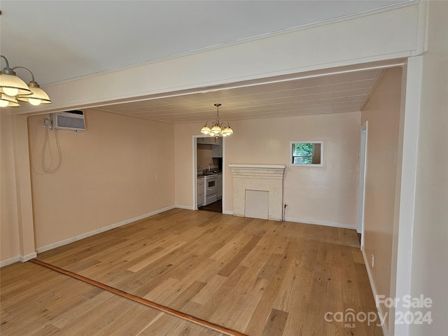 unfurnished living room featuring hardwood / wood-style flooring and a wall mounted air conditioner