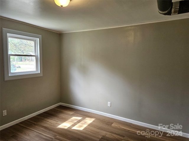 empty room with crown molding and hardwood / wood-style flooring