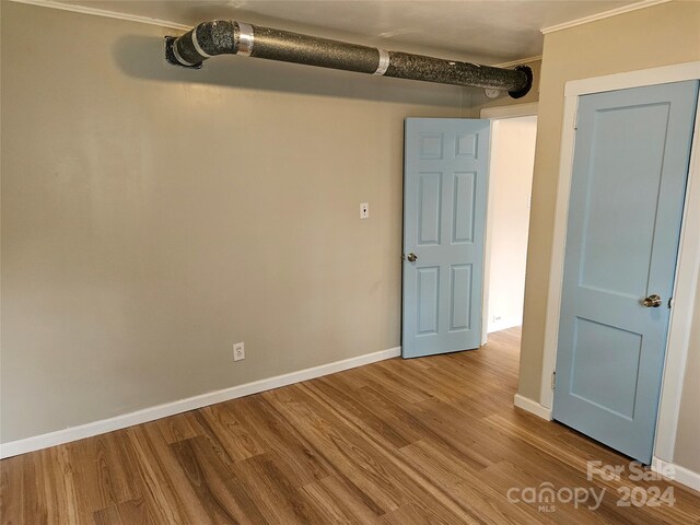 unfurnished room with wood-type flooring and ornamental molding