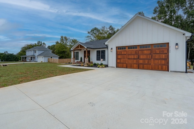 modern farmhouse featuring a front lawn and a garage