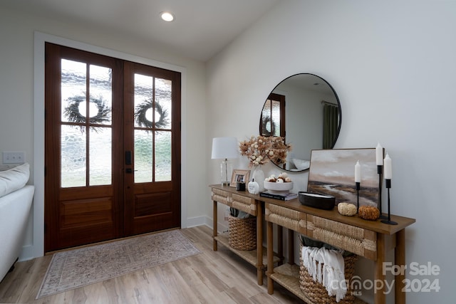 entryway featuring vaulted ceiling, light hardwood / wood-style floors, and french doors