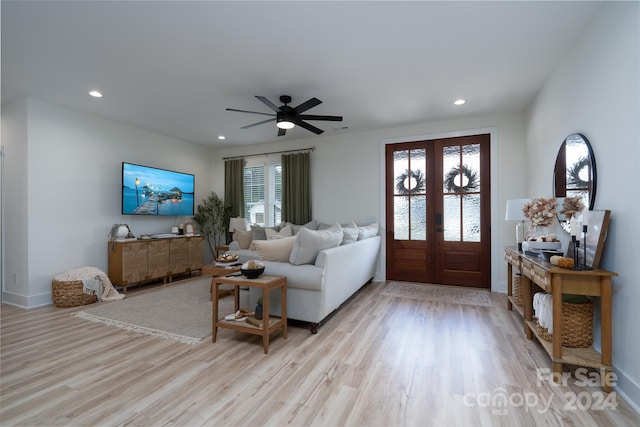 living room with ceiling fan, light hardwood / wood-style flooring, and french doors