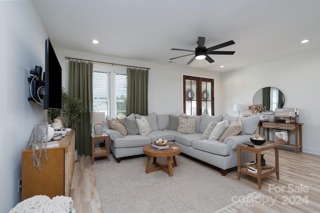 living room featuring french doors, light wood-type flooring, ceiling fan, and a healthy amount of sunlight