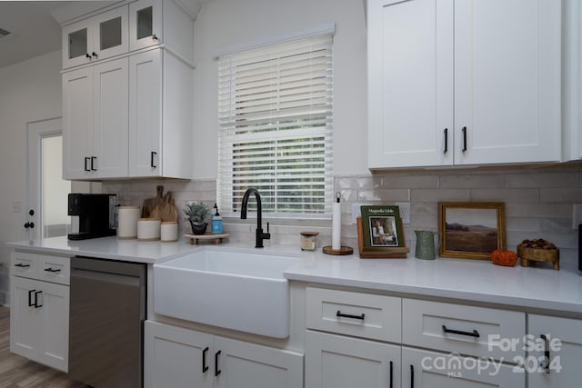 kitchen featuring light hardwood / wood-style floors, sink, white cabinetry, decorative backsplash, and stainless steel dishwasher