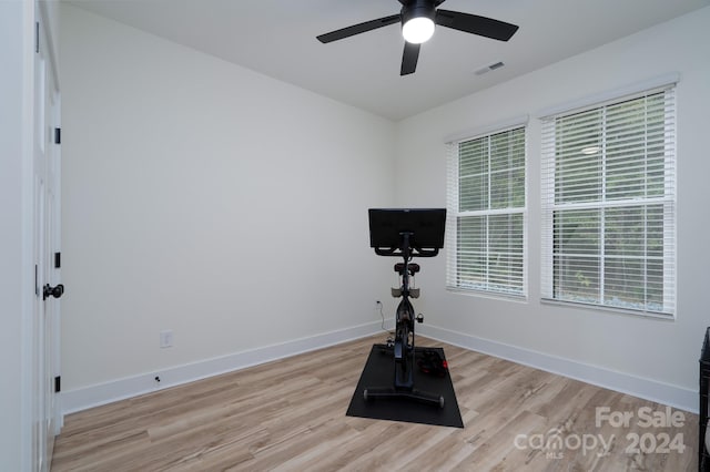 workout room with ceiling fan and light hardwood / wood-style flooring