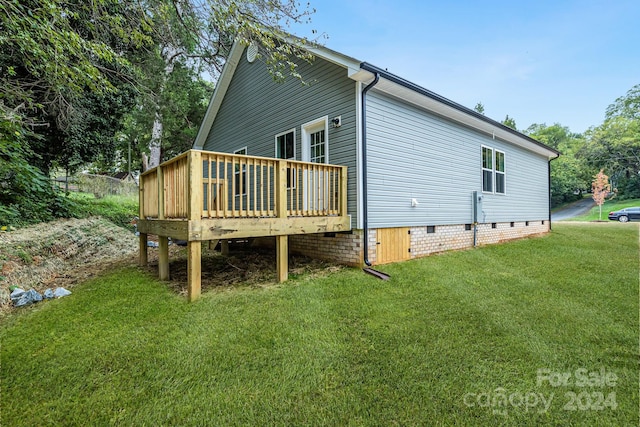 view of property exterior with a wooden deck and a yard