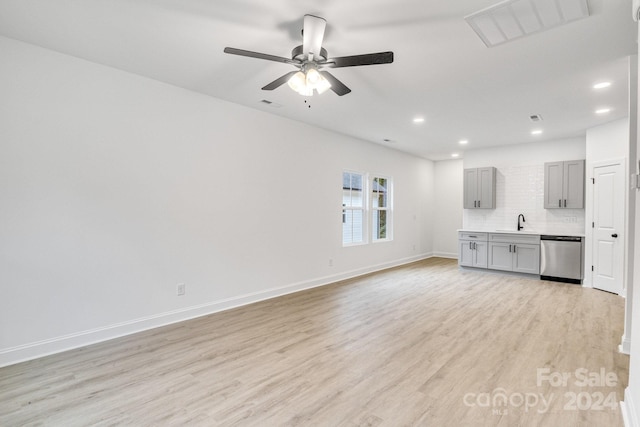 unfurnished living room with ceiling fan, light hardwood / wood-style flooring, and sink