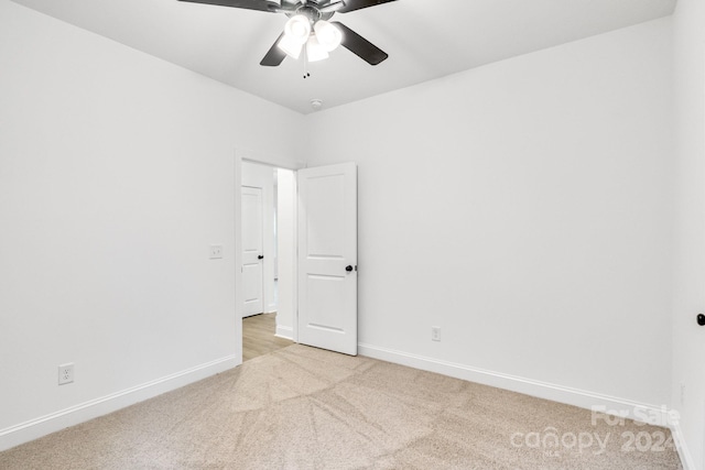 spare room featuring ceiling fan and light colored carpet