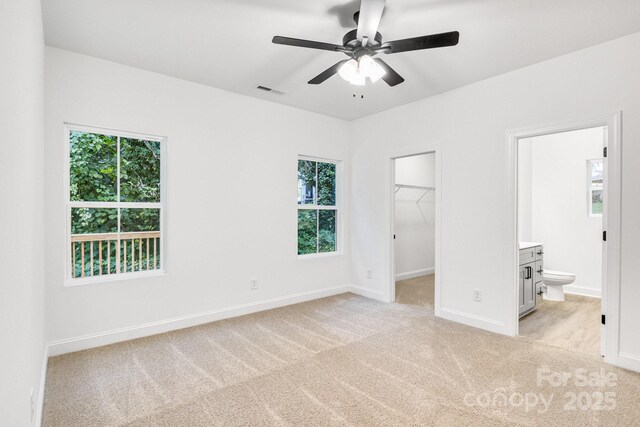 602 Meadow St, Spencer, NC 28159 - unfurnished bedroom with light carpet, a spacious closet, ensuite bath, a closet, and a ceiling fan