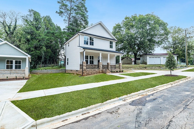 view of front of property featuring an outdoor structure, a garage, a front lawn, and a porch