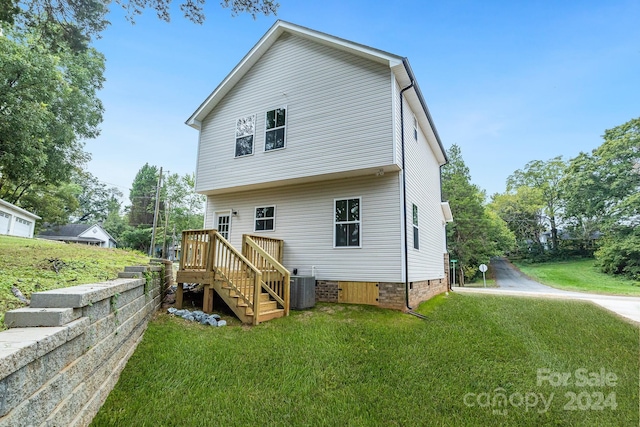 rear view of house with a lawn, central air condition unit, and a wooden deck