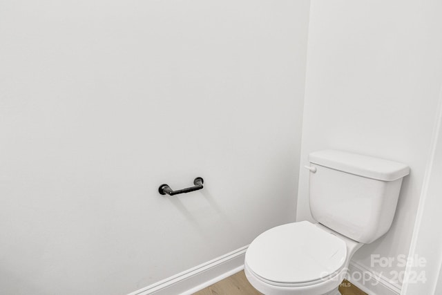 bathroom with toilet and hardwood / wood-style flooring