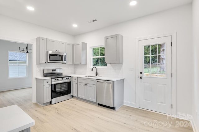 kitchen with a wealth of natural light, appliances with stainless steel finishes, and sink