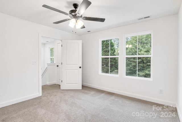 carpeted spare room with ceiling fan