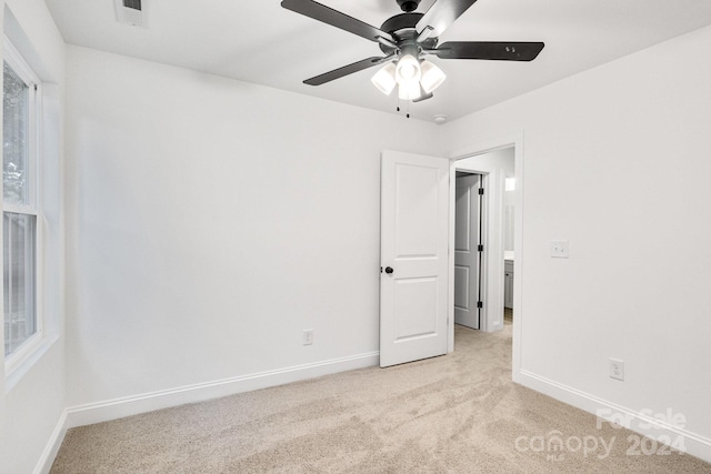 carpeted spare room with ceiling fan