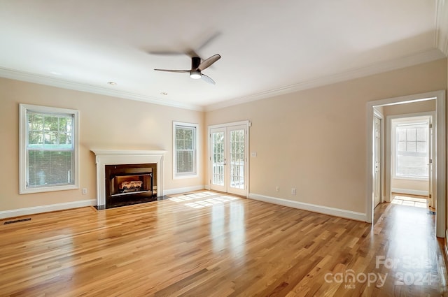 unfurnished living room featuring ornamental molding, light hardwood / wood-style floors, and a wealth of natural light