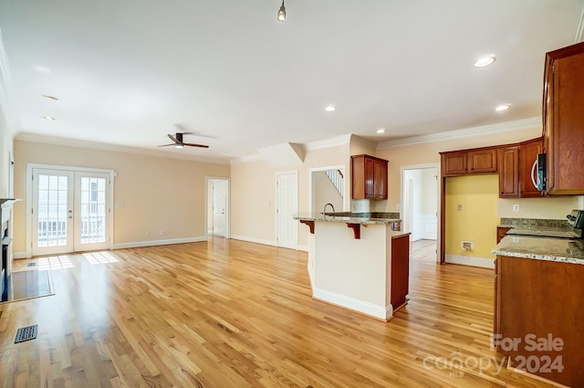 kitchen featuring french doors, light hardwood / wood-style floors, crown molding, and range