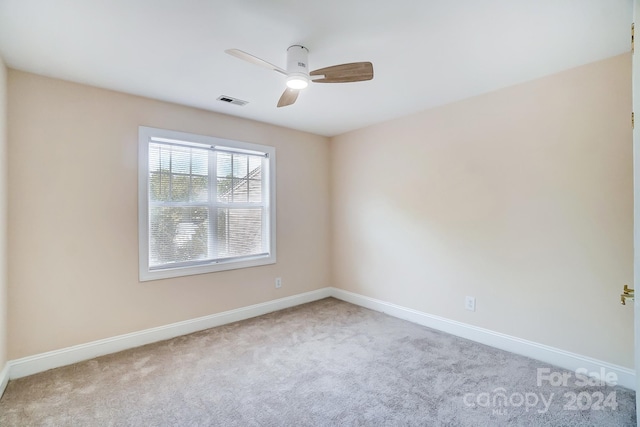 spare room with ceiling fan and light colored carpet