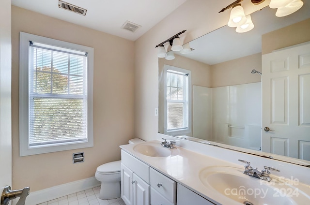 bathroom with tile patterned flooring, a shower, vanity, and toilet