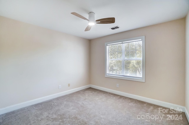 carpeted spare room featuring ceiling fan