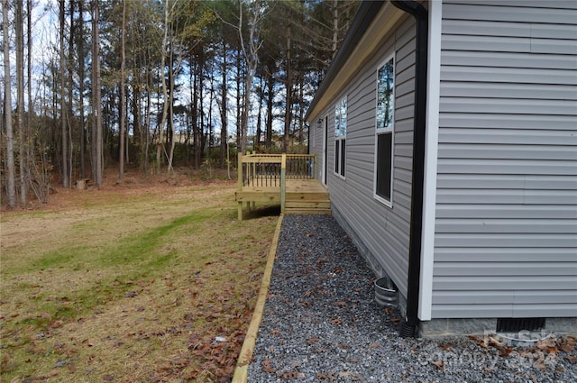 view of side of home with a lawn and a deck