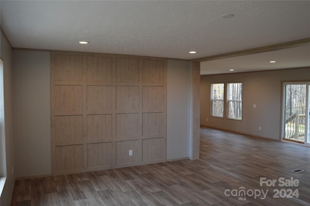 unfurnished room featuring hardwood / wood-style floors and a textured ceiling