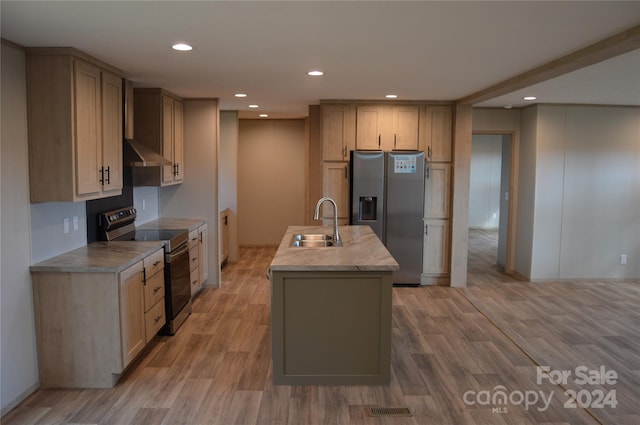 kitchen with wall chimney range hood, appliances with stainless steel finishes, light hardwood / wood-style flooring, and sink