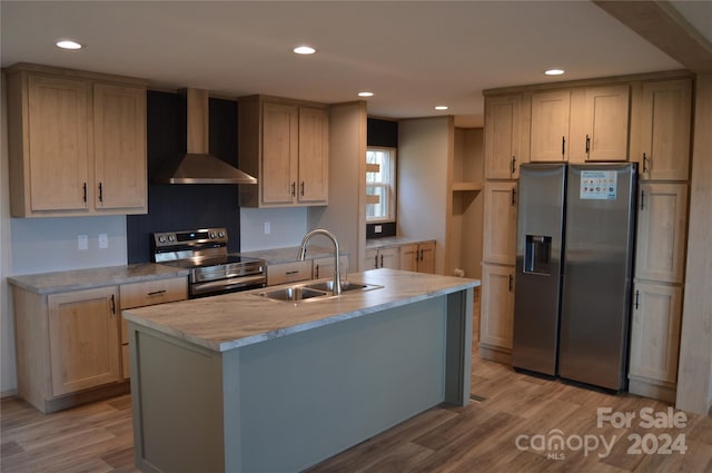 kitchen featuring sink, stainless steel appliances, light hardwood / wood-style flooring, and wall chimney range hood