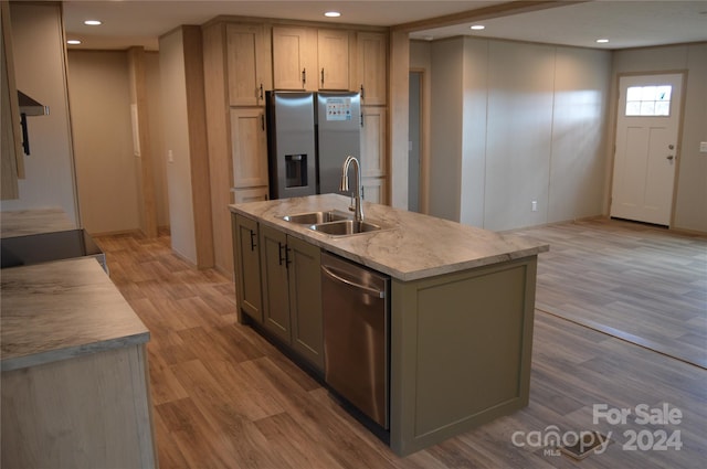 kitchen featuring light wood-type flooring, an island with sink, range hood, and stainless steel appliances