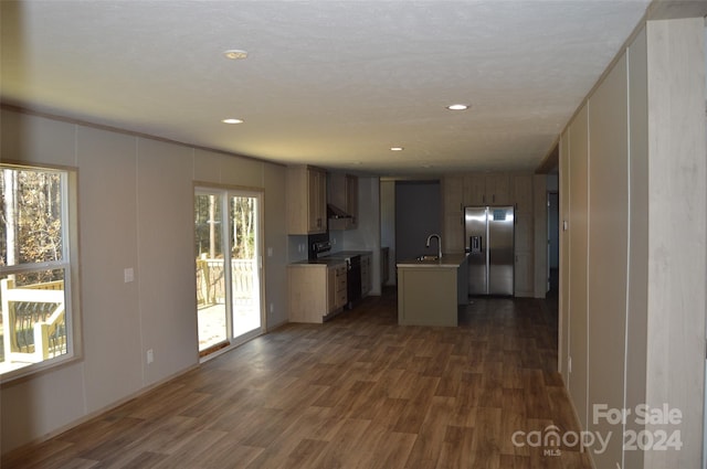 kitchen with stainless steel refrigerator with ice dispenser, a textured ceiling, a kitchen island with sink, dark hardwood / wood-style floors, and range with electric stovetop