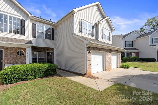 view of property featuring a garage and a front yard