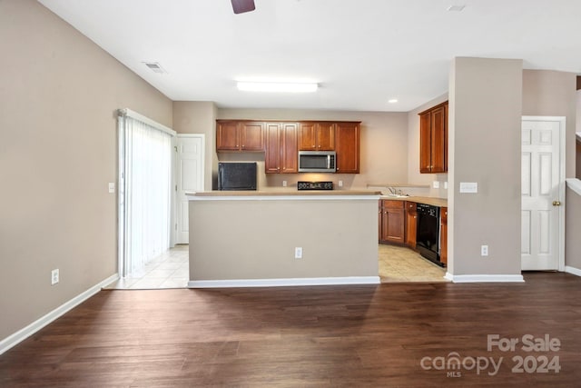 kitchen featuring a kitchen island, black appliances, ceiling fan, hardwood / wood-style floors, and sink