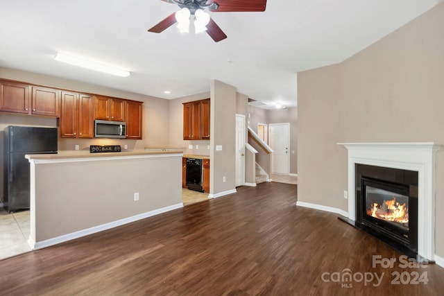 kitchen featuring ceiling fan, dark hardwood / wood-style floors, black refrigerator, and a center island