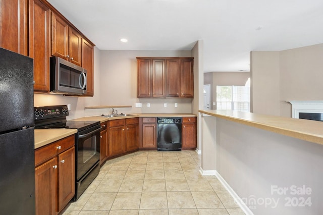 kitchen featuring light tile patterned flooring, sink, and black appliances