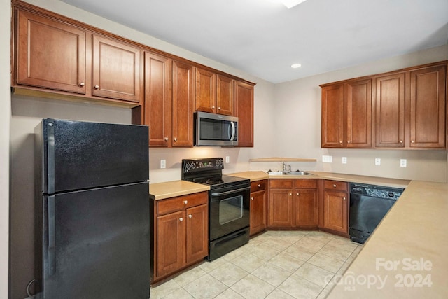 kitchen with black appliances, light tile patterned floors, and sink