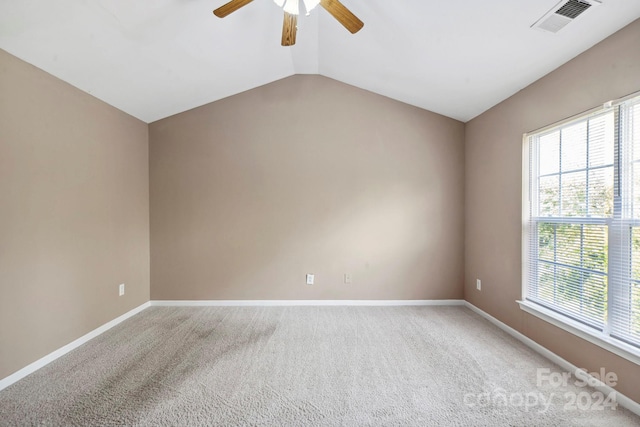 carpeted spare room featuring ceiling fan and lofted ceiling